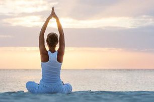 Caucasian woman practicing yoga at seashore Caucasian woman practicing yoga at seashore